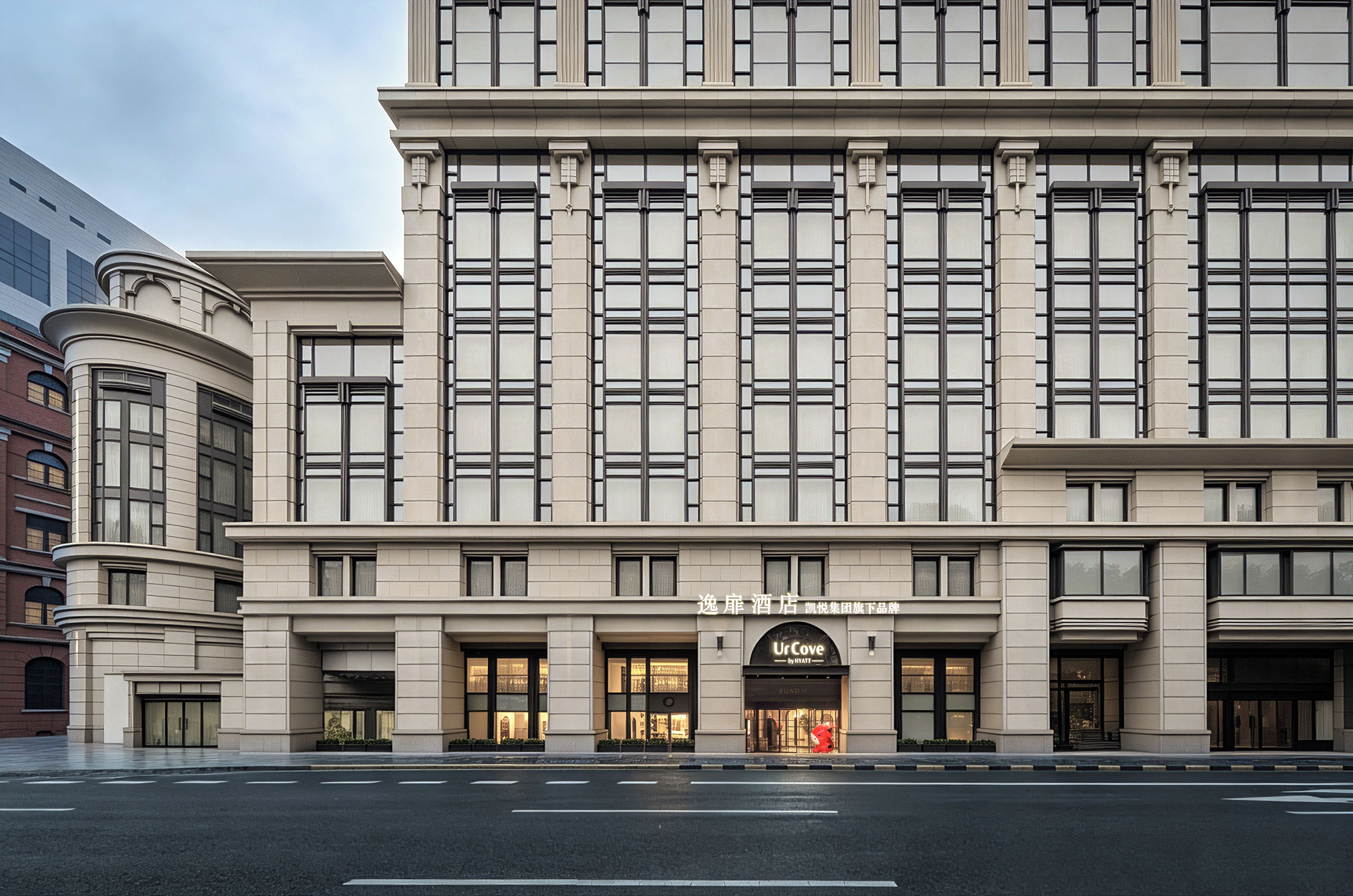 A hotel with a classical facade, large windows, and a prominent 'UrCove by Hyatt' sign.