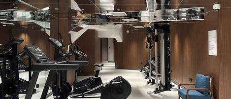 A gym with treadmills, exercise bikes, and weight machines.