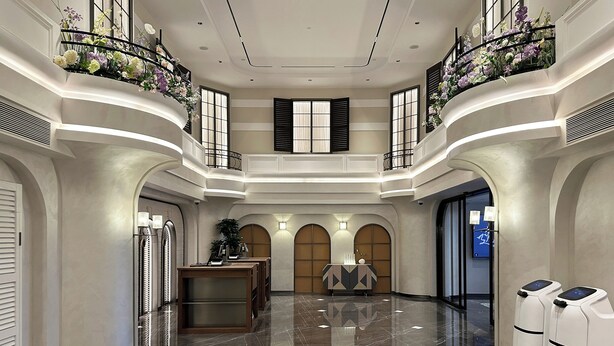 Eine geräumige Lobby mit hoher Decke, einer Rezeption und einer Sitzecke.