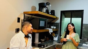 Una cocina moderna con encimera de madera, una cafetera y una ventana.