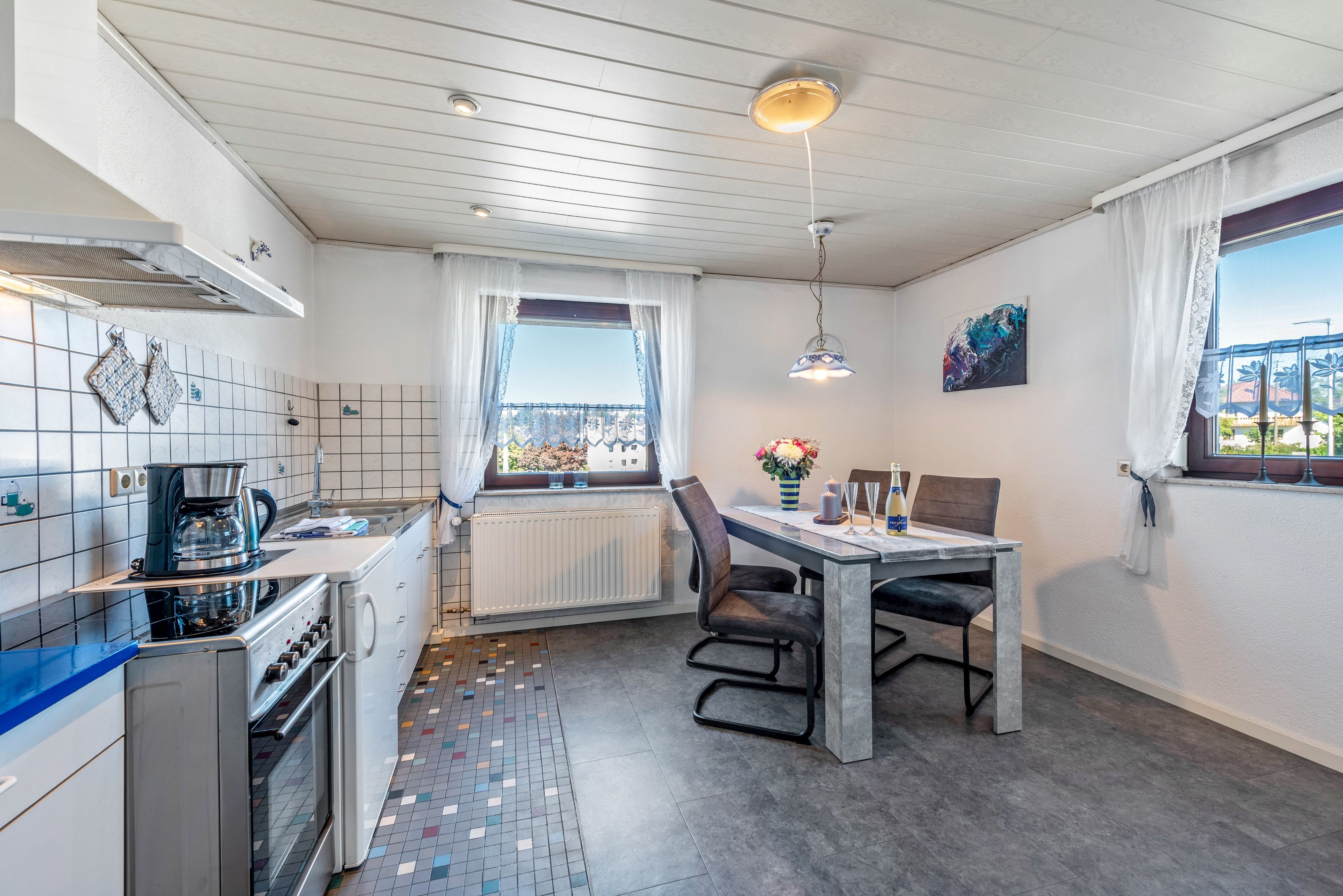 Une cuisine moderne avec un coin repas, une fenêtre offrant une belle vue et un radiateur.