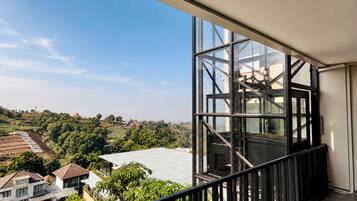 Un balcón con vistas a una zona residencial y una gran estructura de ventanales.