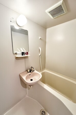 A bathroom with a sink, mirror, and toilet. - Casa G.S. Ebisucho (Osaka)