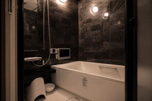 Une salle de bain moderne Ă©quipĂ©e dâune baignoire, de toilettes et dâun espace douche.