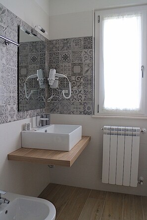 Een douche, een haardroger, een bidet, handdoeken