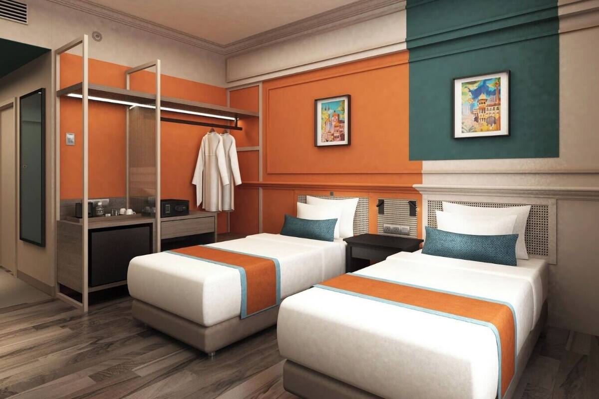 Een hotelkamer met twee bedden, een bureau, een kledingkast en kunst aan de muren.