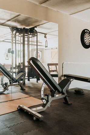 A gym with weightlifting equipment, including a bench press and a squat rack.