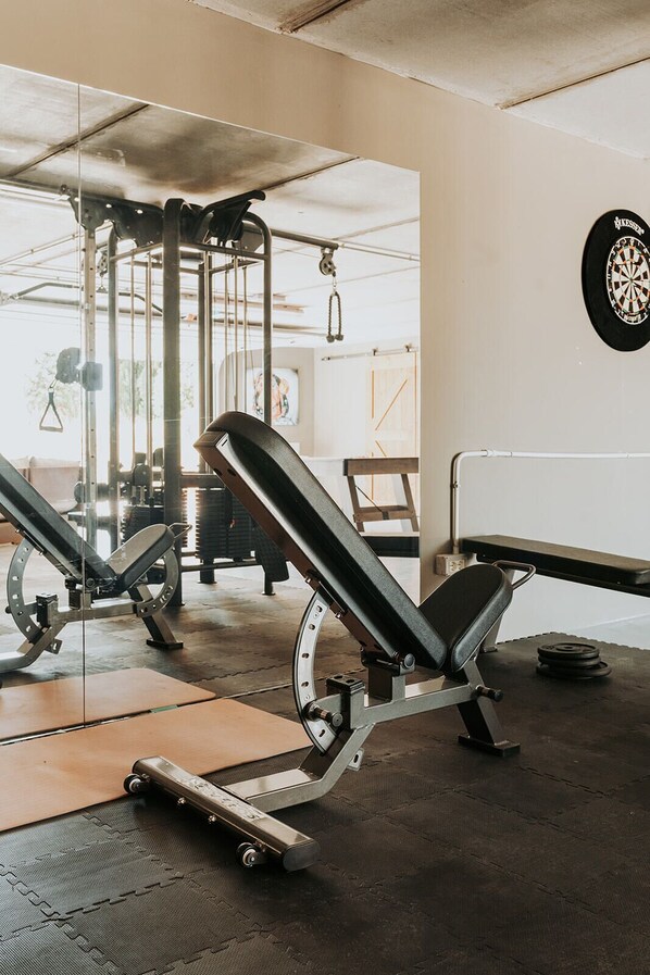 A gym with weightlifting equipment, including a bench press and a squat rack.