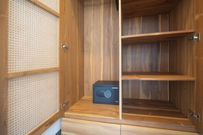 Un gabinete de madera con puerta de malla, un dispositivo electrónico negro y un estante de madera.