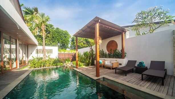 A modern outdoor pool area with a wooden deck, lounge chairs, and a covered seating area. - Brand New 3Bedroom Lucky Lotus Villa Private Pool (Bali)