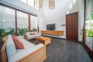 Una sala de estar moderna con sofá, mesa de centro y televisor.