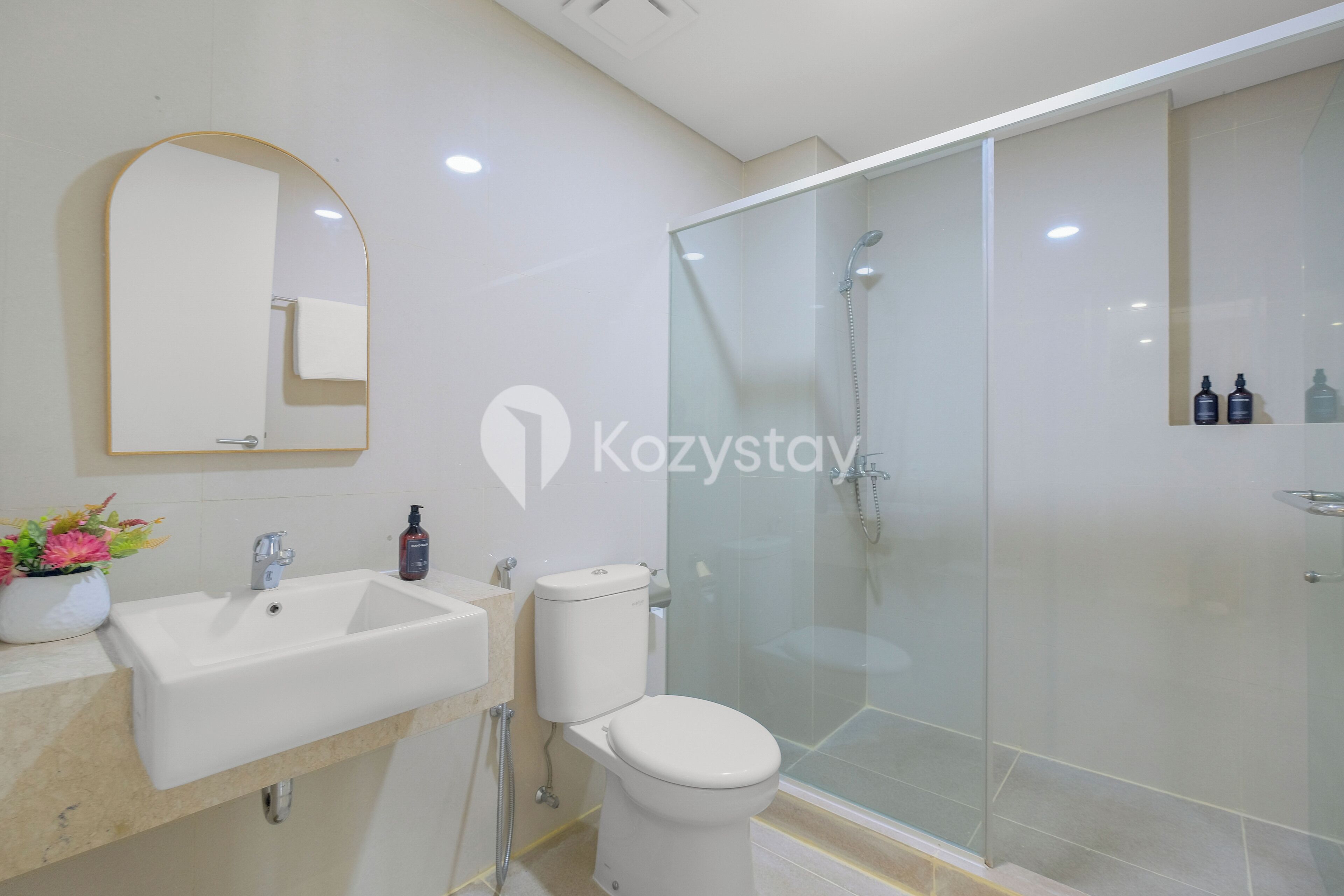 A modern bathroom with a sink, toilet, and glass-enclosed shower.
