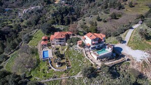 An aerial view of a resort with multiple buildings, a swimming pool, and a landscaped area.