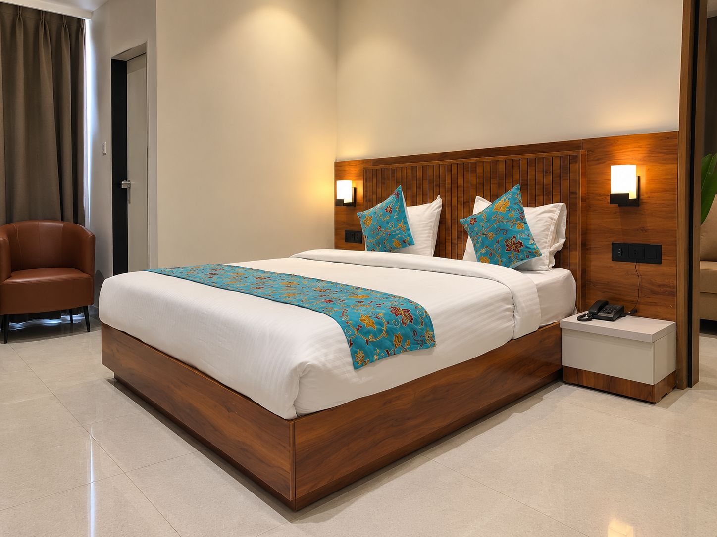 A hotel room with a wooden bed frame, white bedding, and decorative pillows.