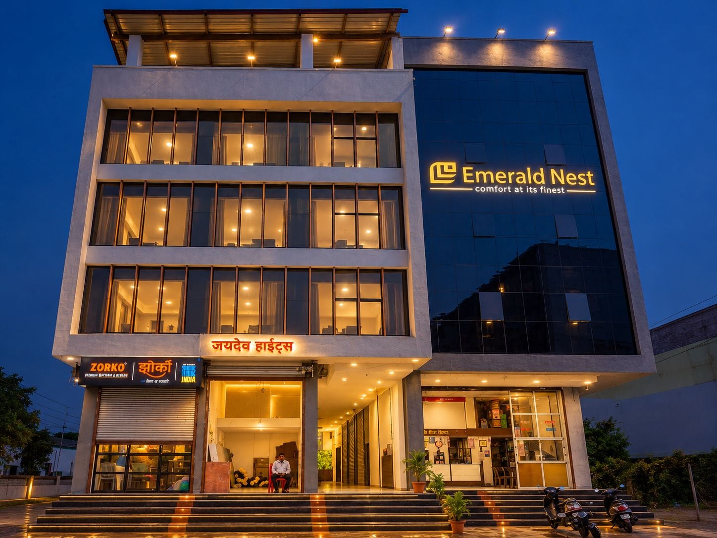 Un hotel de varios pisos con un letrero llamativo que dice 'Emerald Nest' y una entrada visible con escalones que llevan a la puerta.