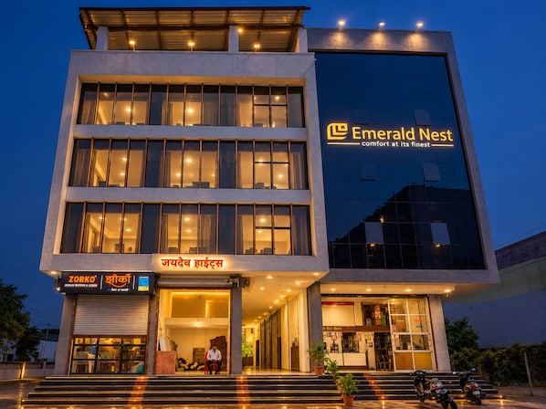A multi-story hotel with a prominent sign for 'Emerald Nest' and a visible entrance with steps leading up to the door. - Emerald Nest (Pandharpur)