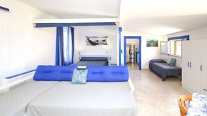 A bedroom with a bed, a sofa, a desk, and a chair. - Vista mare, ampio terrazzo e aria condizionata (Castelsardo SS)