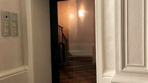 En hall med ett rutmönstrat golv som leder till en trappa.