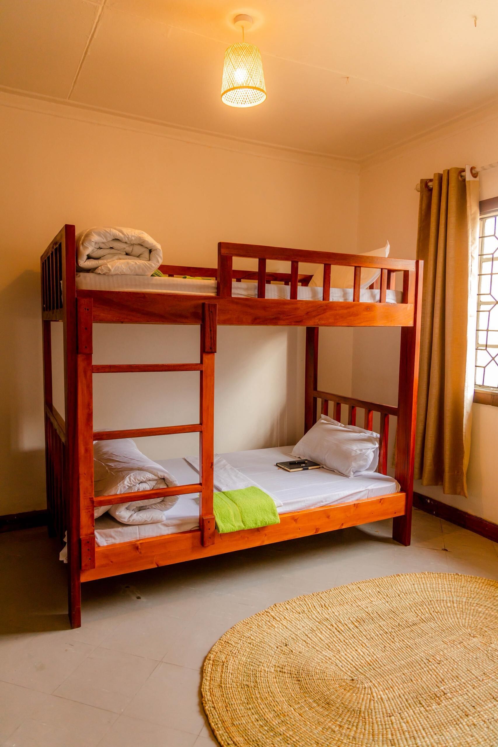 A bunk bed with a woven mat on the floor.