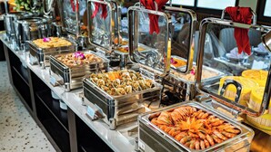 Ein Buffet mit verschiedenen Speisen in Metallbehältern, anrechtet auf einer Theke.