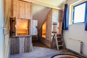 A room with wooden walls, a ladder, and a window. - Peaceful Bungalow Near the Shore (Ewijk)