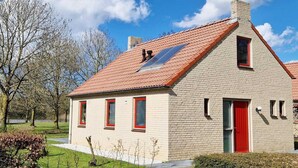Ein eingeschossiges Gebäude mit rotem Ziegeldach, einer roten Tür und einem kleinen Fenster.