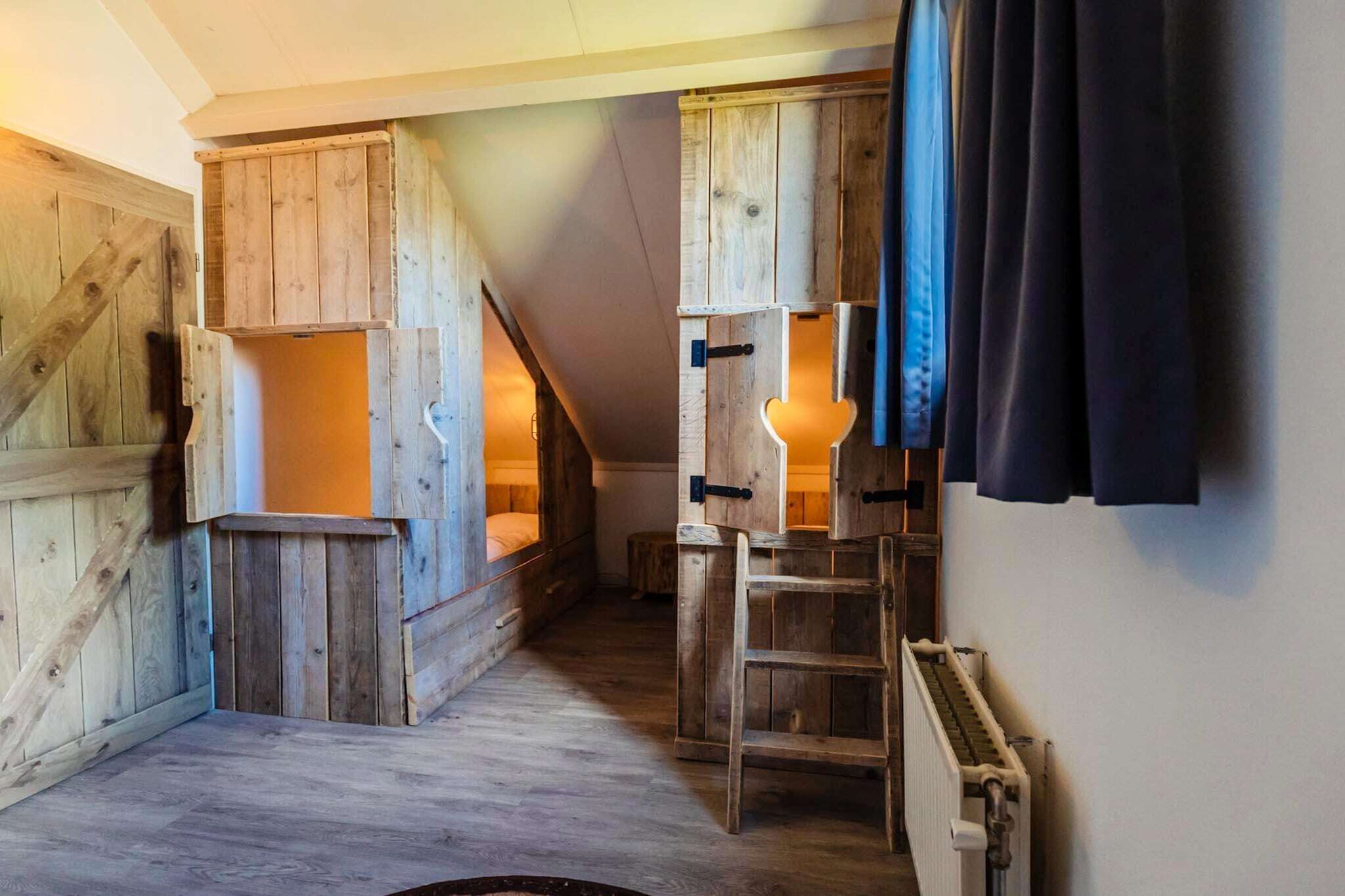 Una habitación rústica con paredes de madera, una cama en altillo, una escalera y un radiador.