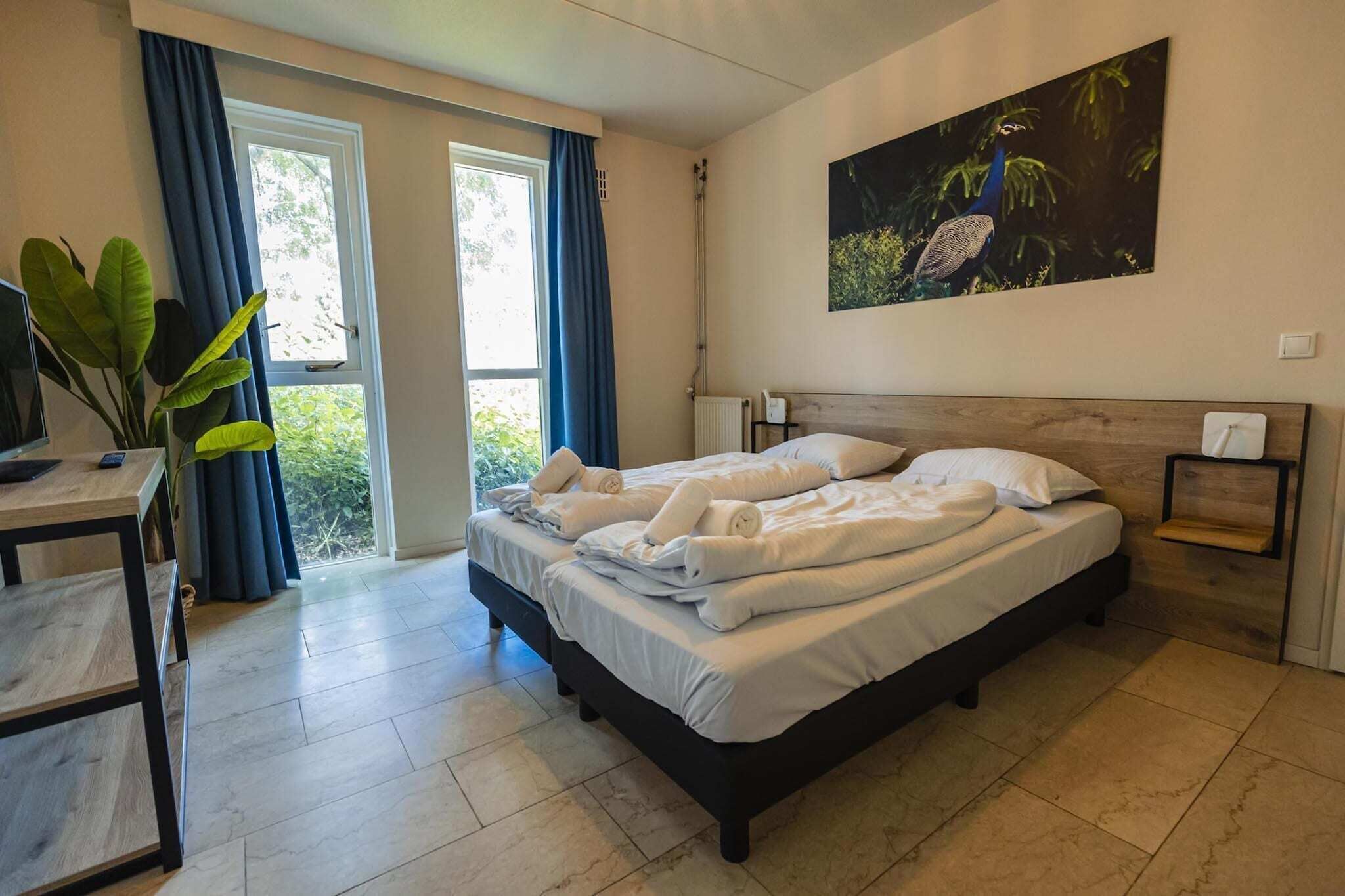 Una camera da letto con un letto, una scrivania, una sedia, una finestra con tende e un quadro appeso al muro.