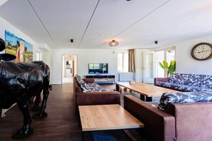 Ein modernes Wohnzimmer mit Sofa, Couchtisch und Fernseher.