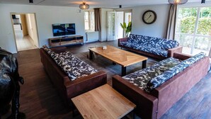 Ein modernes Wohnzimmer mit einer Sofagarnitur, einem Couchtisch und einem Fernseher.