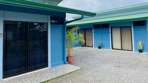 Un edificio con paredes exteriores azules y un camino de entrada de grava.