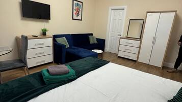 Tabla de planchar con plancha, internet y ropa de cama