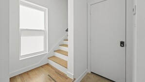 A staircase with wooden steps and a white door with a lock. - Modern Townhome Dallas Bishop Arts (Dallas)