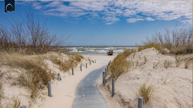 A sandy beach path leading to the ocean with a boat in the distance. - Modern vacation apartment with sauna & garden - close to nature and comfortable on Usedom - (Loddin)