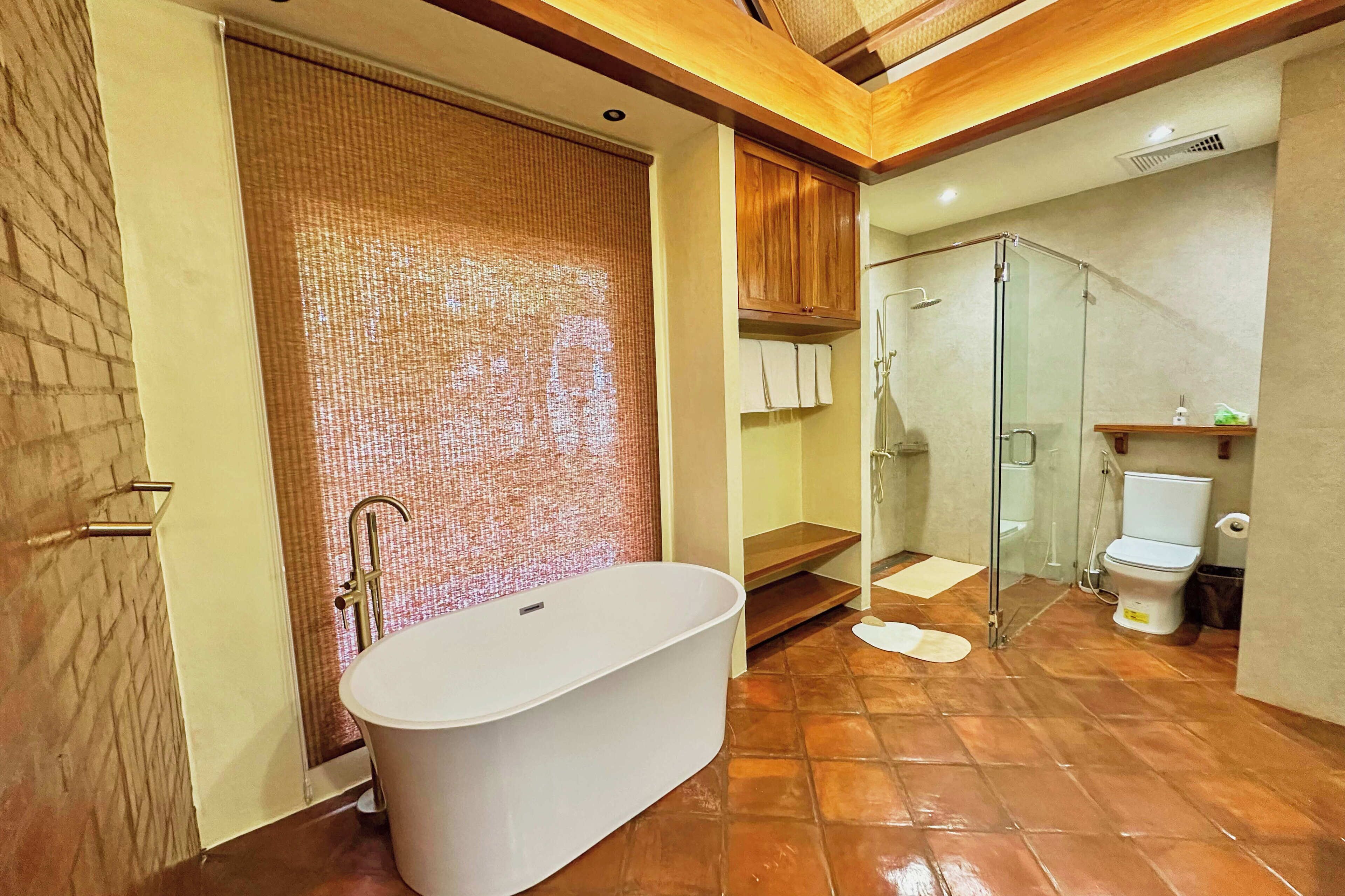A modern bathroom with a freestanding bathtub, a glass-enclosed shower, and a toilet.