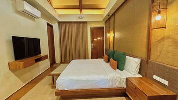 A hotel room with a bed, bedside table, TV, and a ceiling fan.