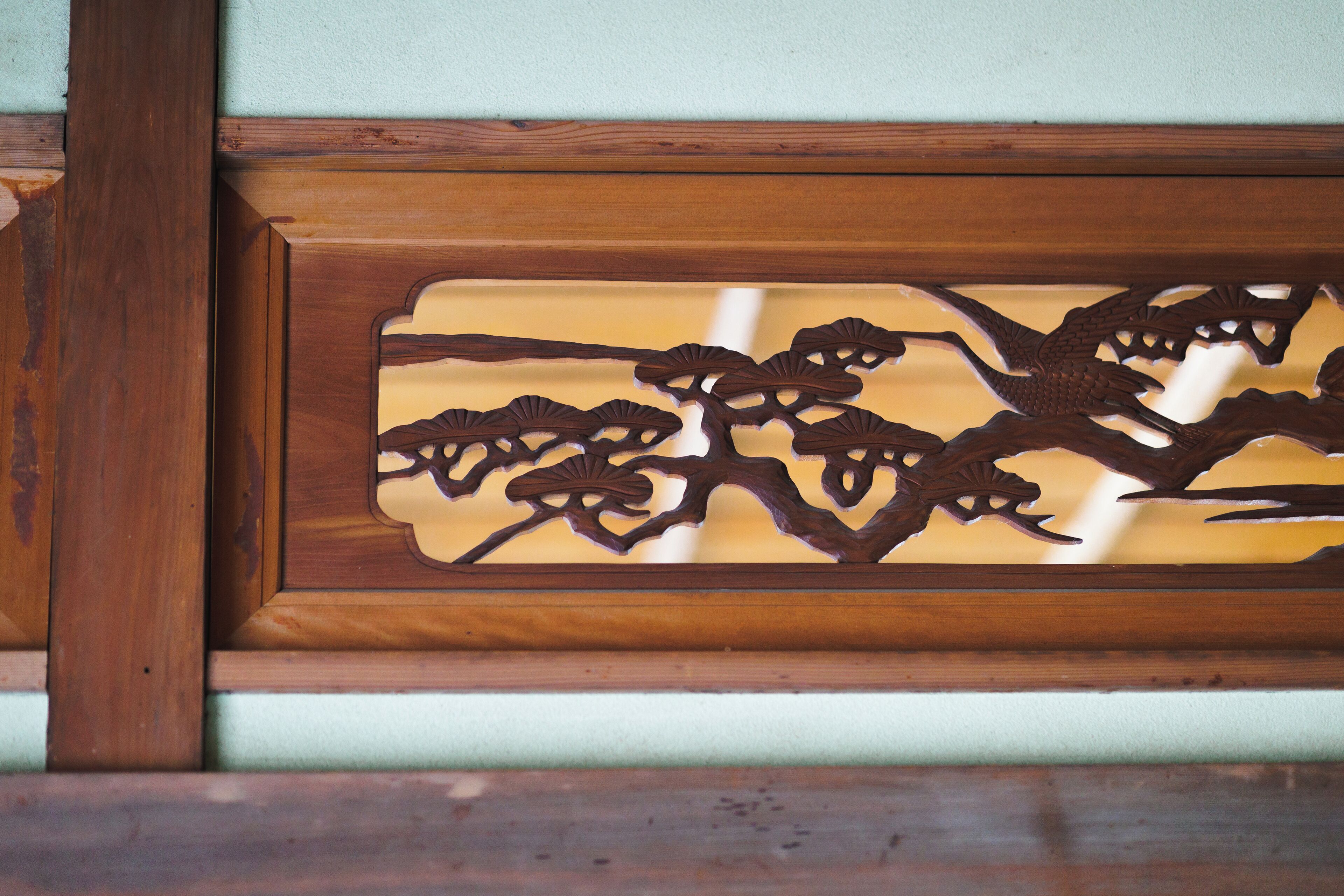 A wooden panel with intricate carvings of branches and leaves.