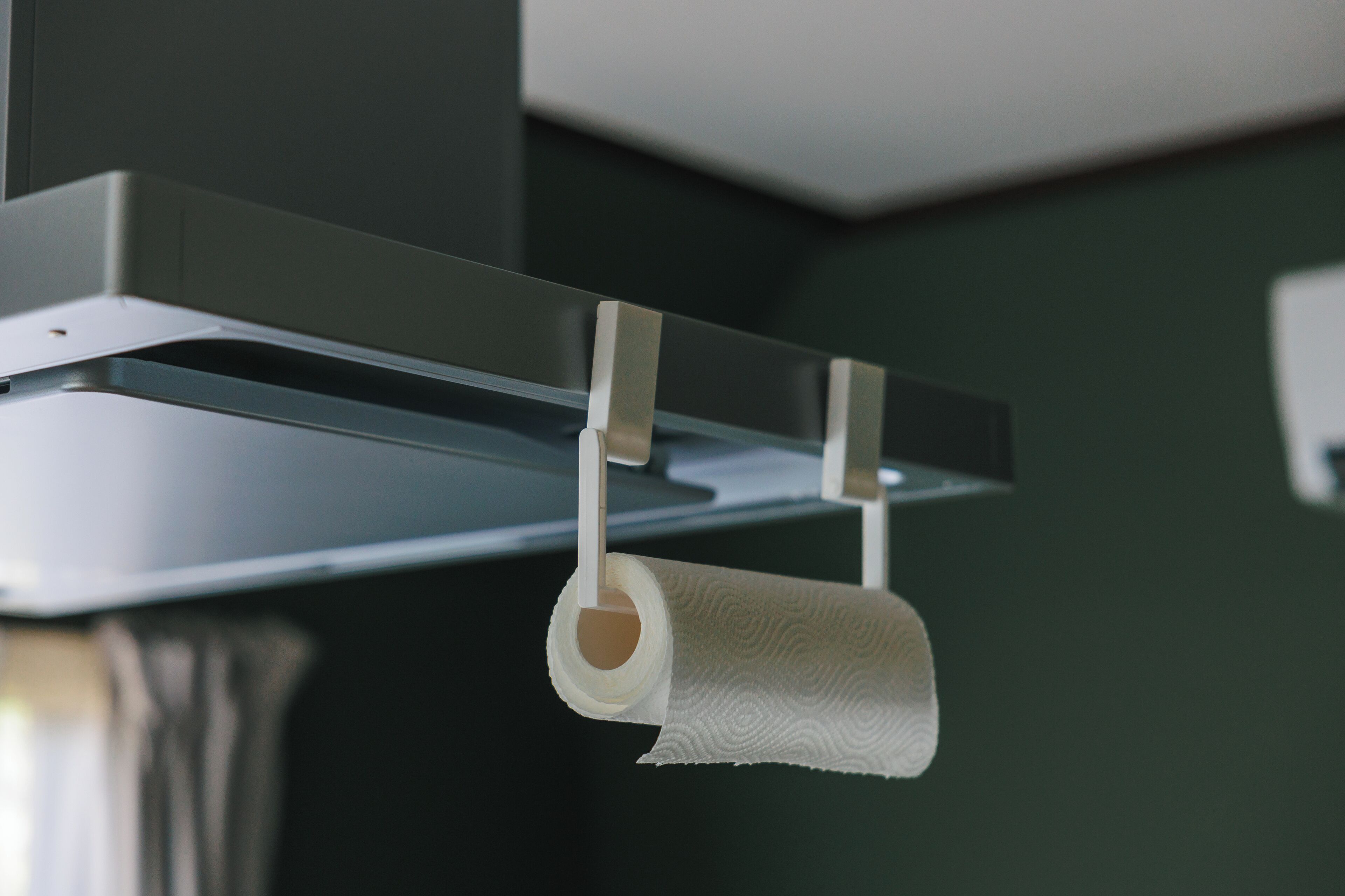 A toilet paper holder with a roll of toilet paper hanging from it.