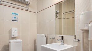 A modern bathroom with a toilet, sink, and shower.