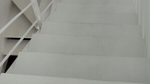 A white staircase with a metal handrail, leading to an upper floor. - Charming 3 bed villa 10 mins to the nearest & most beautiful beach in Mauritius (Morcellement Swan, Pereybere, Grand Baie)