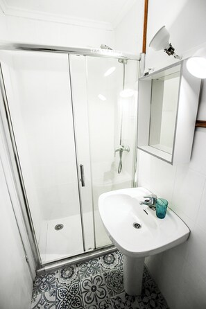Vierpersoonskamer, uitzicht op tuin | Badkamer | Een douche, handdoeken, zeep, shampoo