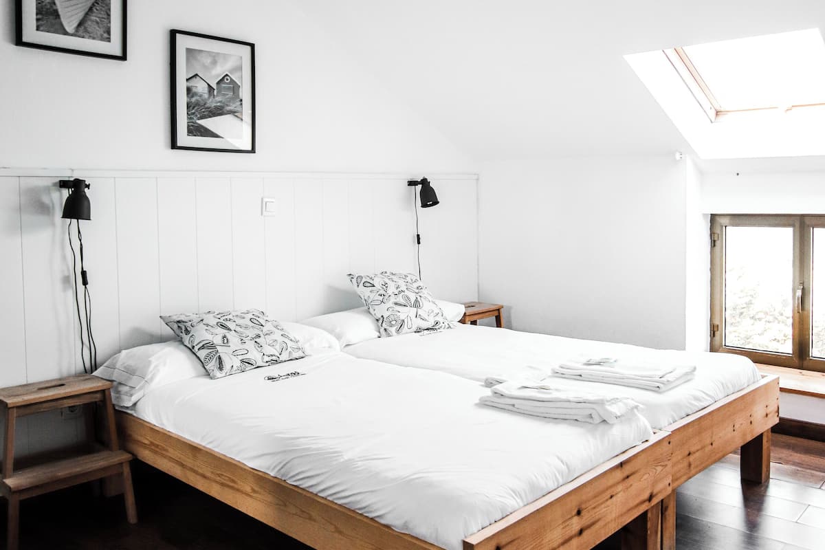 Een slaapkamer met een groot houten bed, een vloerlamp en een plafondlamp.
