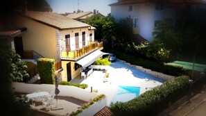 A two-story building with a balcony, a swimming pool, and a car parked nearby. - Pablo accommodation (Rovinj)