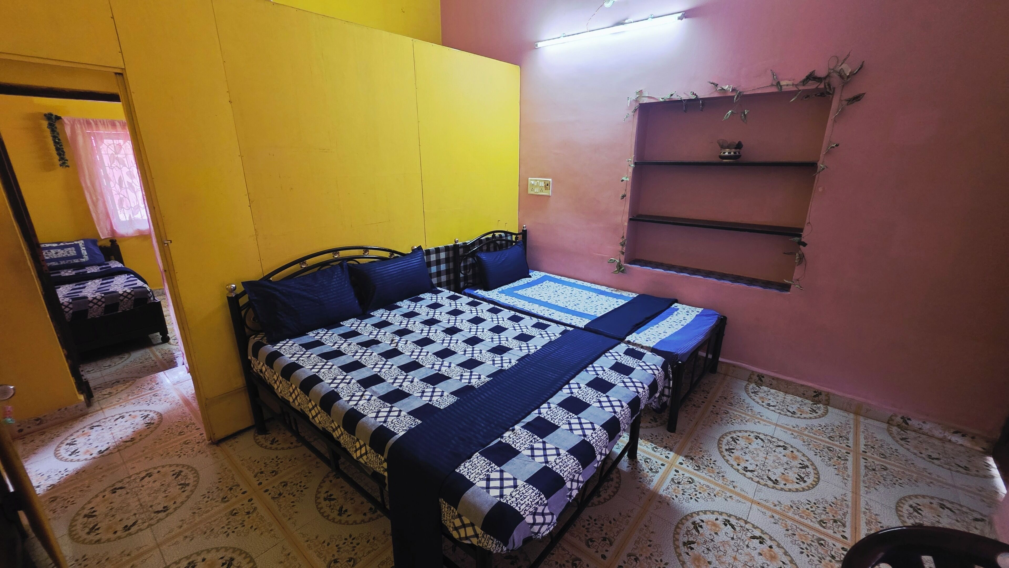 Une chambre à coucher avec un lit, une table de chevet et une étagère.