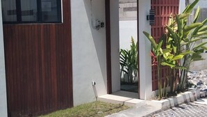 A modern house with a large window, a wooden door, and a paved driveway. - Serene Bali Villa With Private Pool and Antiqued Charm (Denpasar)