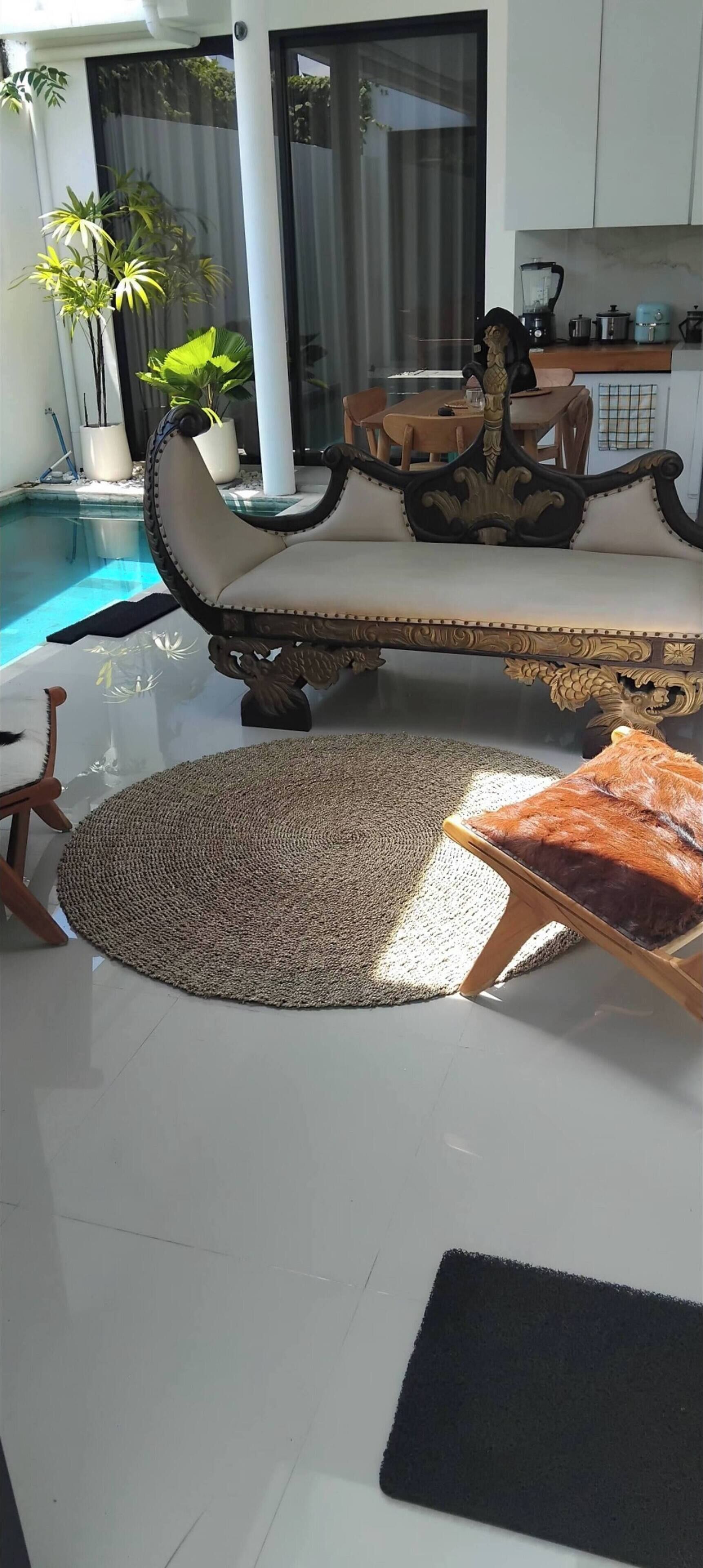 Uma sala de estar moderna com piscina, um sofá, uma mesa de centro e um espaço de jantar.