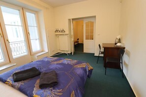 A bedroom with a bed, a desk, a chair, and a radiator. - Fantastic Inn Warsaw - NS42 (Warsaw)