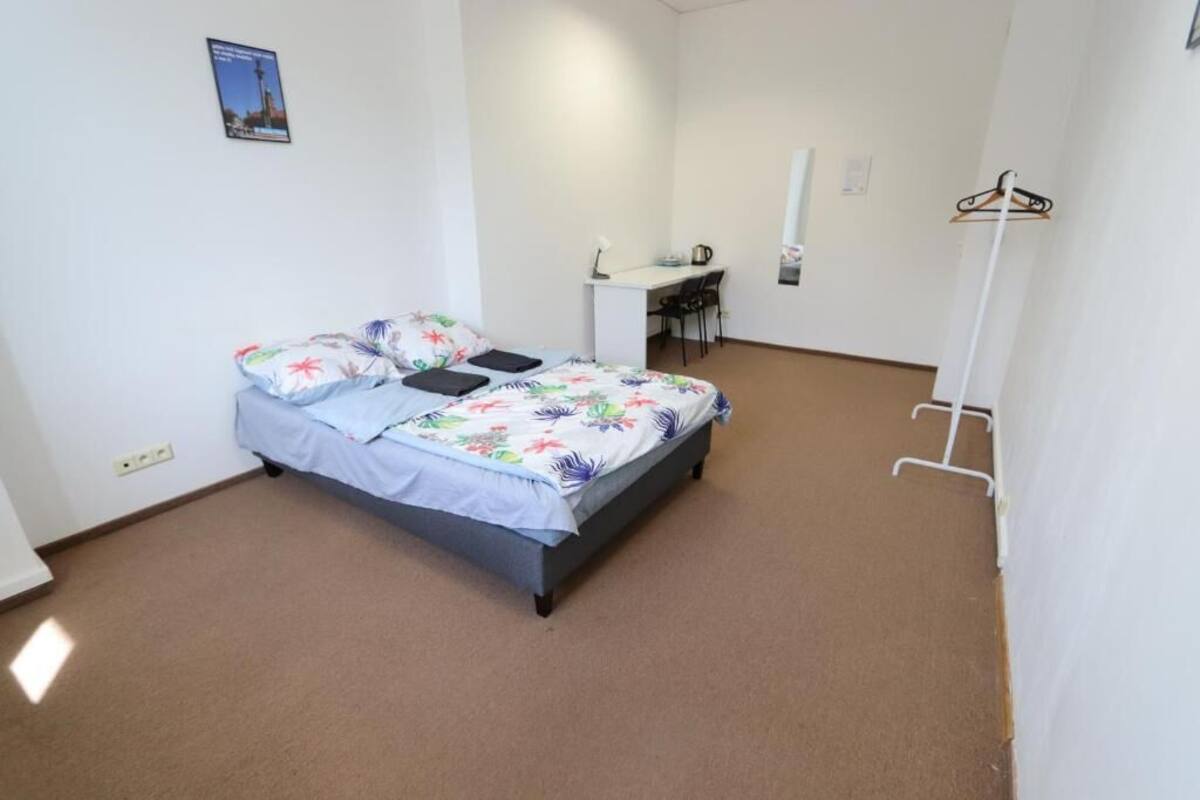 A bedroom with a bed, a desk, and a chair.