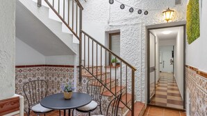 A staircase with a white wall and a checkered floor leading to a room with a table and chairs. - Holiday Home 'Casa Marbella' with Private Terrace, Wi-Fi and Air Conditioning (Fuengirola)