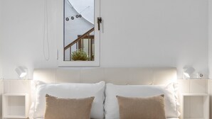 A bedroom with a bed, two pillows, bedside tables, a window, and a view of the outside. - Holiday Home 'Casa Marbella' with Private Terrace, Wi-Fi and Air Conditioning (Fuengirola)